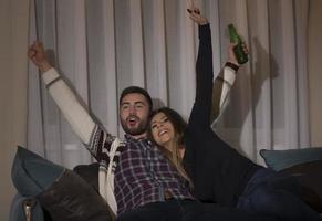 pareja divirtiéndose viendo un partido de fútbol en la televisión foto