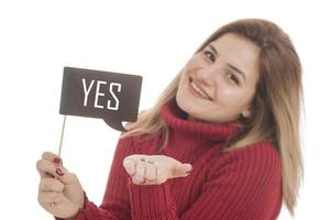 Woman holding engagement ring and sign saying YES photo