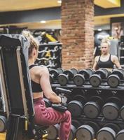 hermosa chica entrena en el gimnasio foto