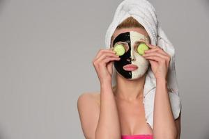 beautiful female model with black and white facial cosmetic mask photo