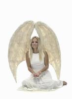 Portrait of beautiful blonde woman with angel's wings. Angel with long curly hair photo