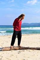 Man balancing on a log on the beach photo