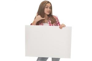 young smiling woman holding a blank sheet of paper for advertising photo