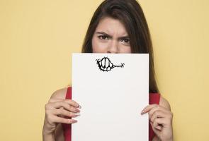 joven mujer sonriente sosteniendo una hoja de papel en blanco para publicidad foto