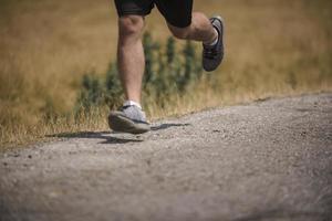 corredor de hombre deportivo corriendo en la meseta de la montaña en verano foto