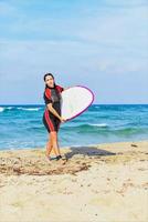 beautiful surfer girl on the beach photo