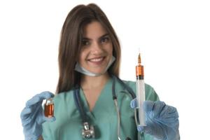 Woman Nurse with protective workwear holding Vaccine and syringe photo