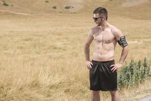 joven atlético que se extiende después de correr en la naturaleza. concepto de deporte foto