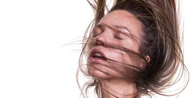 retrato de una mujer hermosa con el pelo largo. joven modelo morena con cabello hermoso - aislado sobre fondo blanco. niña con el pelo volando en el viento. foto