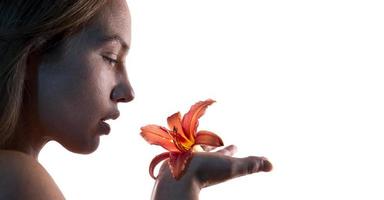 retrato artístico de una mujer sosteniendo una flor de lirio. concepto de belleza. aislado sobre fondo blanco foto
