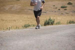 corredor de hombre deportivo corriendo en la meseta de la montaña en verano foto