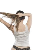 Female model arranging her hair. Woman tying hair in a bun. photo