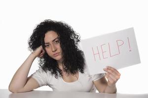 young attractive frustrated and tired businesswoman holding help sign message overworked at office computer, exhausted, sad under pressure and stress isolated on white photo