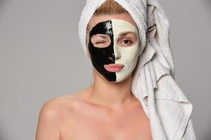 beautiful female model with black and white facial cosmetic mask photo