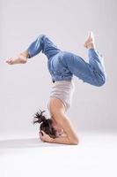 retrato de una hermosa joven con un cuerpo atlético y flexible haciendo estiramientos de piernas. aislado foto