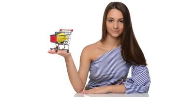 Credit card in a woman's hand and a small souvenir cart. Shopping, wholesale and retail trade, discounts, purchases on credit, credit history.