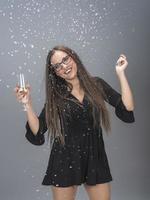 Beautiful woman celebrating New Year with confetti and champagne photo