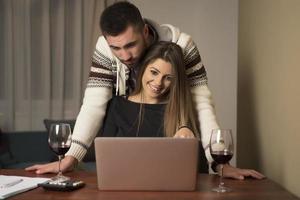 pareja joven administrando finanzas, revisando sus cuentas bancarias usando una computadora portátil. mujer y hombre haciendo papeleo juntos, pagando impuestos en línea en una computadora portátil foto