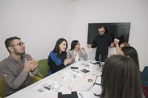 líder ejecutivo hablando con un grupo de empleados diversos felices en la reunión informativa de la oficina corporativa, foto