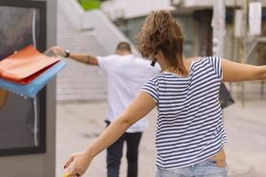 Portrait of cheerful Caucasian young couple man and woman holding many paper bags after shopping while walking and talking on street. Happy family couple with packages outdoor. Buying concept photo