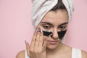 Woman with purifying black mask on her face photo