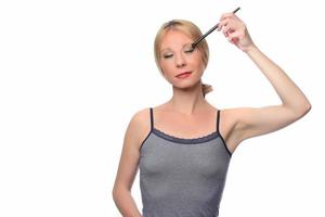 Image of joyful woman smiling at camera and using makeup brush photo