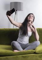 Happy woman listening to music from mobile phone while sitting on the rug beside to the sofa at homes, Smiling girl relaxing with headphones in morning, Time to relax. photo