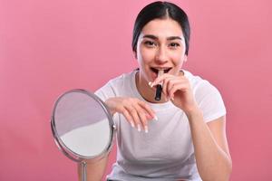 mujer haciendo maquillaje, mirando al espejo. foto