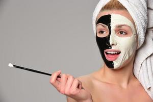 hermosa modelo femenina con máscara cosmética facial en blanco y negro