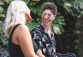 Gay woman smiling and having fun in the park. Same sex young married female couple kissing and showing some affection LGBT photo