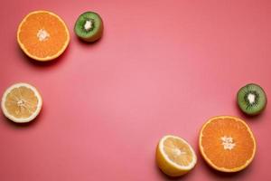 Fruits on the pink background. Orange, lemon, kiwi. Free space for text. photo