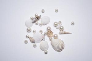 conchas marinas y perlas en el fondo blanco. foto