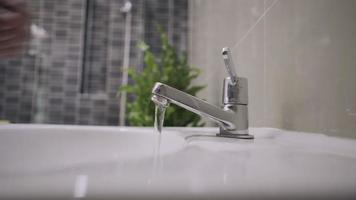 man use hand closes water tap forgot close. Turning off the water not completely closed make no saves energy and make global warming. Concept save energy save water Preserve natural resources video