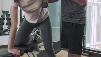 woman is exercising by dumbbell and have support activity by trainer. trainer advice fitness girl and support protect accident . Fitness concept. video