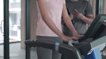 woman is exercising on a treadmill with her trainer advice and record activity details. Exercising in Fitness will be recommended to exercise properly to reduce the risk of injury to your muscles. video