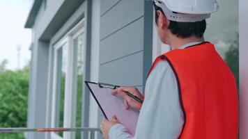 inspecteur of ingenieur is inspecteren en inspecteren een gebouw of huis gebruik makend van een controlelijst. ingenieurs en architecten of contactor werk naar bouwen de huis voordat overhandigen het over- naar de huiseigenaar. video