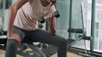 las mujeres hacen ejercicio levantando pesas para fortalecer los músculos. las mujeres hacen ejercicio en fitness para perder peso. concepto de ejercicio en la aptitud para la salud. video