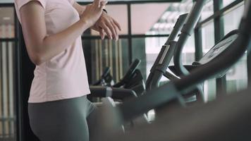 beautiful Asian woman is putting on headphones and playing music on her phone. Listening to music while exercising is a way to relax during activities. Fitness for health concept. video