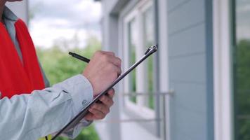 un inspecteur ou un ingénieur inspecte et inspecte un bâtiment ou une maison à l'aide d'une liste de contrôle. ingénieurs et architectes ou entrepreneur travaillent pour construire la maison avant de la remettre au propriétaire. video