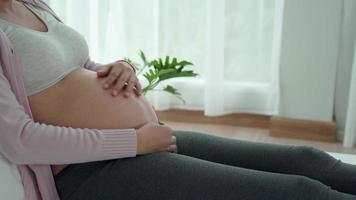 concepto de embarazada. las mujeres embarazadas usan el tacto manual en el estómago durante 8 meses de embarazo. palmear el vientre durante el embarazo es un gesto común de los gestos para captar las reacciones del feto. video