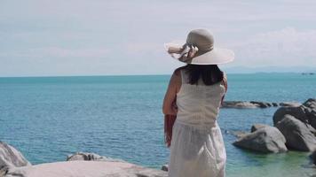 recreación sobre el concepto de lejía. las mujeres lucieron vestidos y velos que se mecían con el viento disfrutando del ambiente playero. mujer sola de viaje en el mar en vacaciones. video