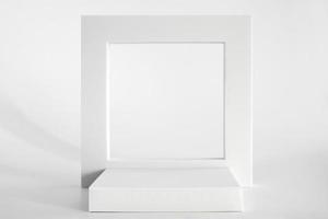 White podium on the white background, simple geometric forms. Podium for product, cosmetic presentation. Creative mock up. Pedestal or platform for beauty products. photo