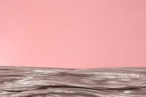 Shiny silver fabric on pink background. Free space, copy space for your text and design. Events, celebrations, Christmas, New Year. Trendy backdrop. photo