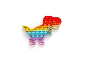 Rainbow Pop it fidget toy on white background. Antistress children game. Children's trendy silicone toys pop it to relieve stress and develop hand motor skills. Colorful hand toy with push bubbles. photo