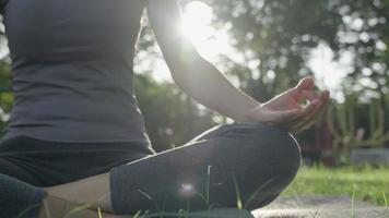 mujer practicando meditar en el parque. mujer asiática haciendo ejercicios por la mañana. equilibrio, recreación, relajación, calma, buena salud, feliz, relax, estilo de vida saludable, reducir el estrés, paz, actitud. video