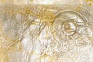 Golden and silver sparkles in water. Glitter and liquid texture. Abstract background with golden an silver particles. Shining celebration background. Festive backdrop for your projects. photo