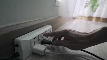 concept of save. Unplug the power plug after not being used will reduce your electricity bill. man is unplugging his appliances after not use to save electricity and reduce costs. video