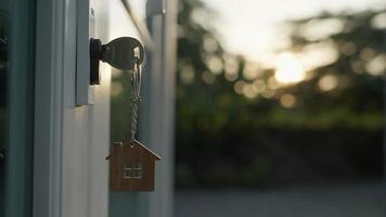 Vermieter Hausschlüssel zum Aufschließen eines Hauses wird in die Tür gesteckt. Haus aus zweiter Hand zu vermieten und zu verkaufen. Schlüsselbund weht im Wind. Vermieter für neues Haus, Miete, Verkauf, Renovierung, Investition. video