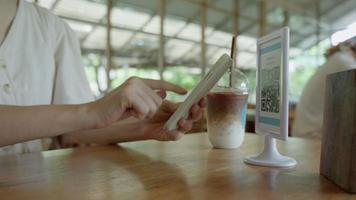 femme utilise un smartphone pour scanner le code qr dans le café. le restaurant et l'hôtel ont construit un système de paiement numérique sans espèces. paiement par code qr, portefeuille électronique, technologie de paiement en espèces, paiement en ligne
