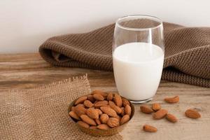 leche de almendras frescas en vaso, bebida saludable vegana no láctea. mesa de madera, primer plano. foto
